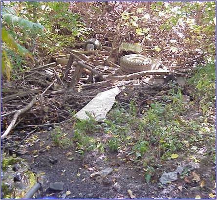 Material thrown in a creek valley instead of appropriate locations.
