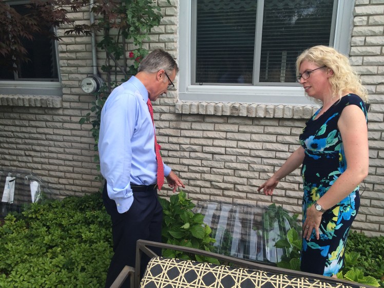 Burlington Mayor Goldring and Cheryl Evans, Director of the Home Flood Protection Program point to a window well cover.